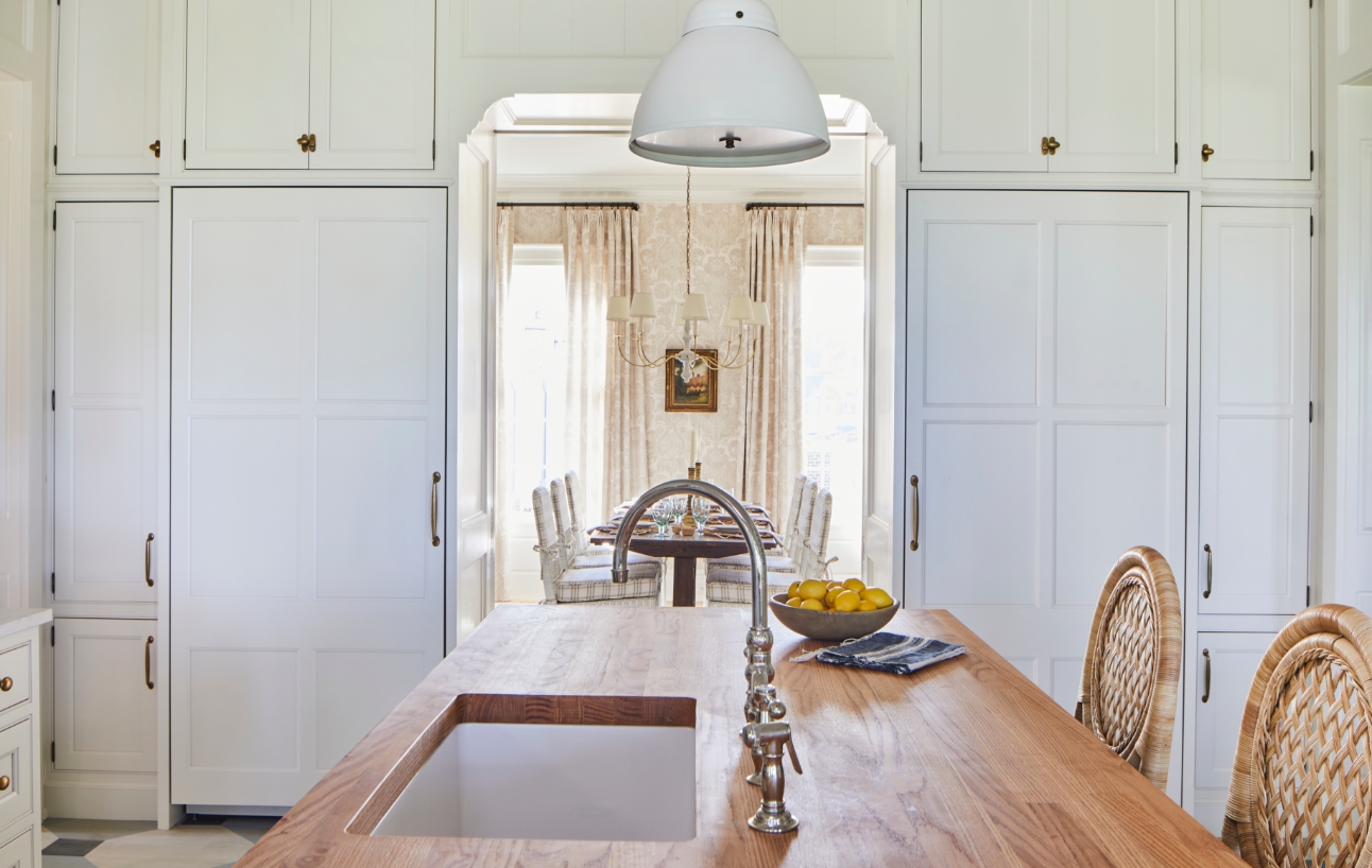Wall of white kitchen cabinets with a pair of integrated column refrigerators