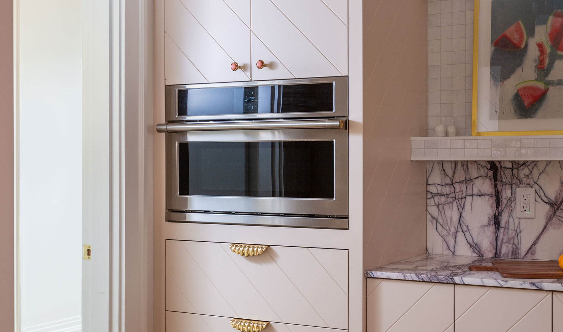 Monogram 48 in. Range with pink pastel cabinets and marble backsplash